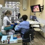 эндодонтист лечит зубы под микроскопом